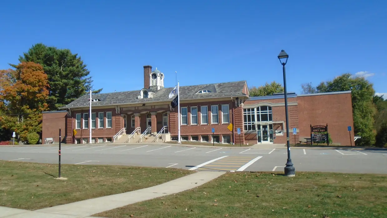 The brick Charlton Town Hall behind its lawn and parking lot